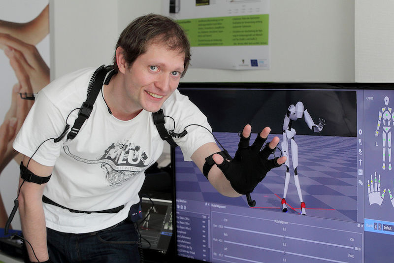 Karsten Helbig zeigt, wie sein Anzug die Bewegungen auf den Computer überträgt.