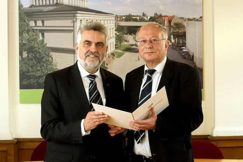 Wissenschaftsminister Armin Willingmann (links) übergibt einen Förderbescheid an Rektor Udo Sträter.