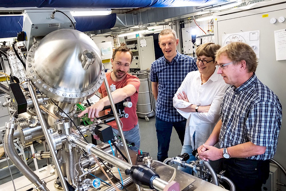 Stefan Förster bespricht mit Manuel Bibes, Ingrid Mertig und Wolf Widdra (v.l.) ein neues Experiment im Physik-Institut.