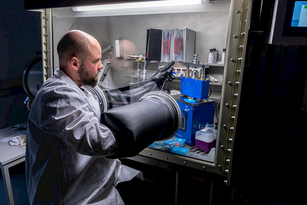 NORCSI-Mitarbeiter René-Pierre Geiß bei der Fertigung von Testbatterien unter Schutzgasatmosphäre in einer Handschuhbox.