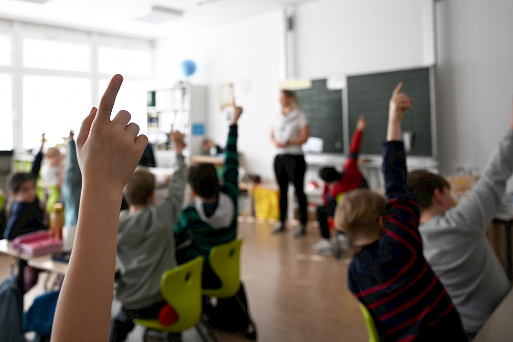 Schülerinnen und Schüler melden sich im Klassenraum.