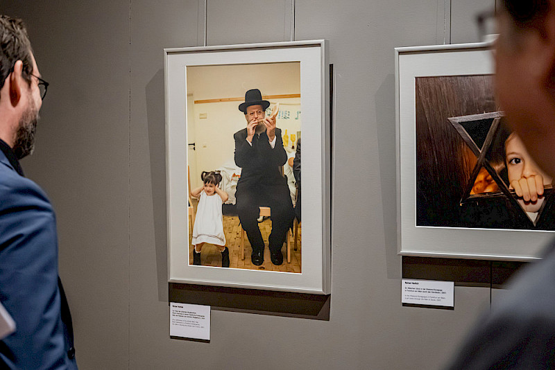 Das Bild zeigt einen Rabbiner, der beim jüdischen Neujahrsfest in einem Frankfurter Kindergarten den Schofar bläst - das Kind neben ihm hält sich die Ohren zu.