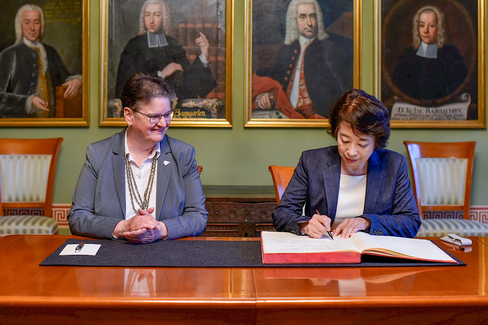 Botschafterin Mitsuko Shino trug sich nach ihrem Gespräch mit Rektorin Claudia Becker ins Goldene Buch der Universität ein.