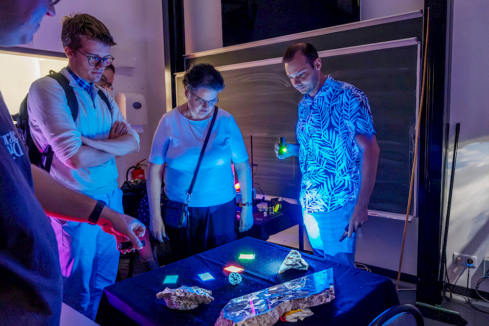 Rektorin Claudia Becker im "Minerale-Darkroom" des Instituts für Geowissenschaften und Geographie, in dem Minerale zum Leuchten gebracht wurden.