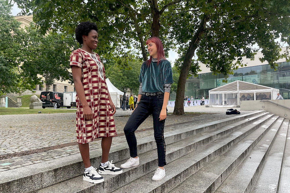 Débora Amenyinyon (links) aus Togo und ihr Buddy Miriam Neuber auf der Freitreppe am Uniplatz