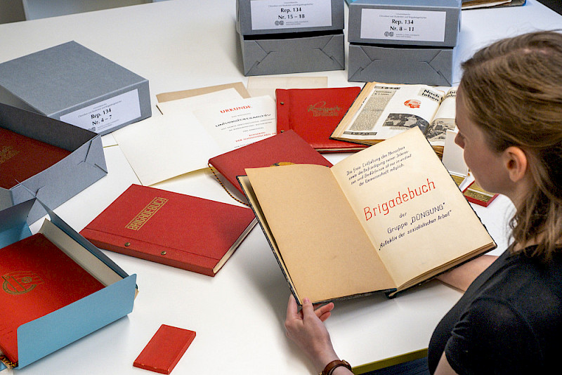 Tabea Schmeitzner hält das Brigadetagebuch der Gruppe "Düngung" in der Hand.