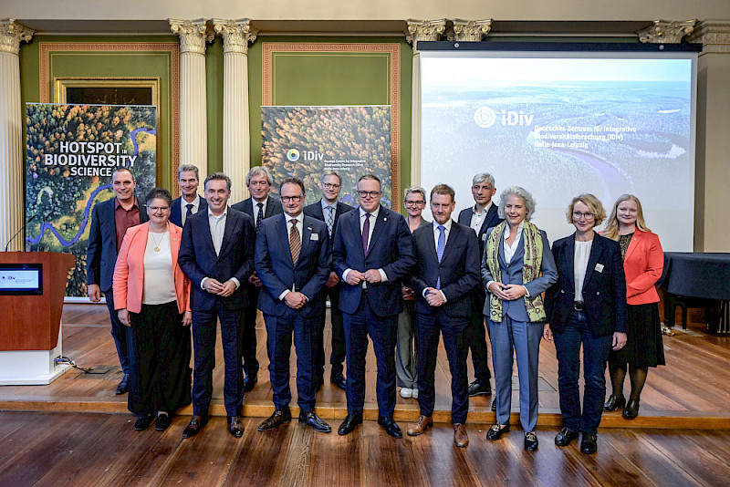 Gruppenfoto mit vielen Wegbegleiterinnen und -begleitern von iDiv. Vordere Reihe von links: Claudia Becker, Thomas Wünsch, Andreas Marx, Mario Voigt, Michael Kretschmer, Eva Inés Obergfell, Katrin Böhning-Gaese, hintere Reihe von links: Martin Quaas, Alfred Funk, Jörg Wadzack, Johannes Grave, Sabine Matthiä, Thoralf Held, Anne Wesemann