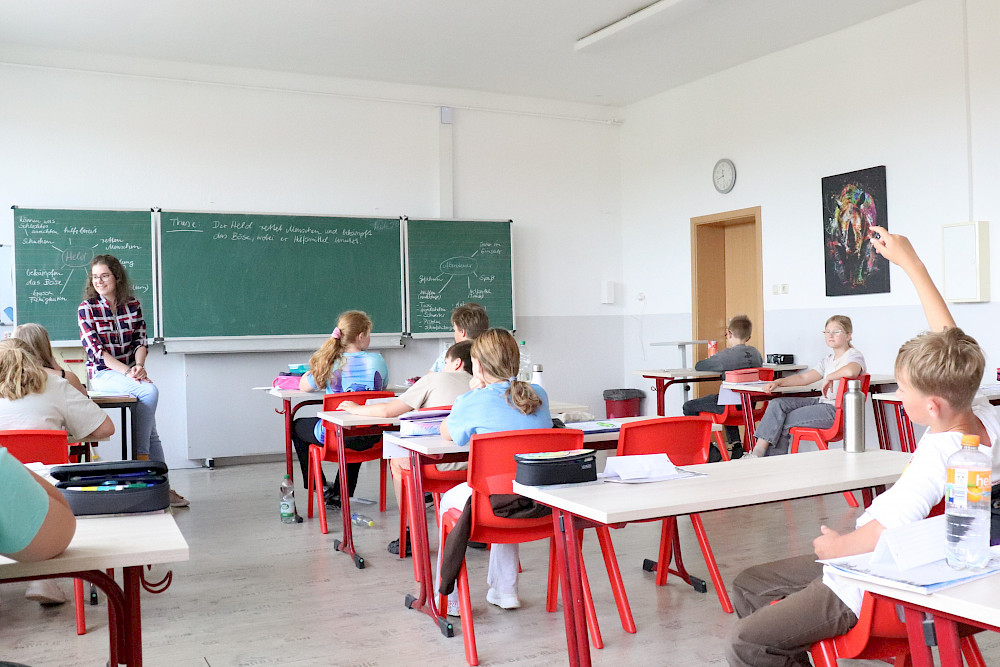 Johanna Luise Giest spricht mit Schülerinnen und Schülern der Sekundarschule Nienburg über mittelalterliche Abenteuer- und Heldenmotive.