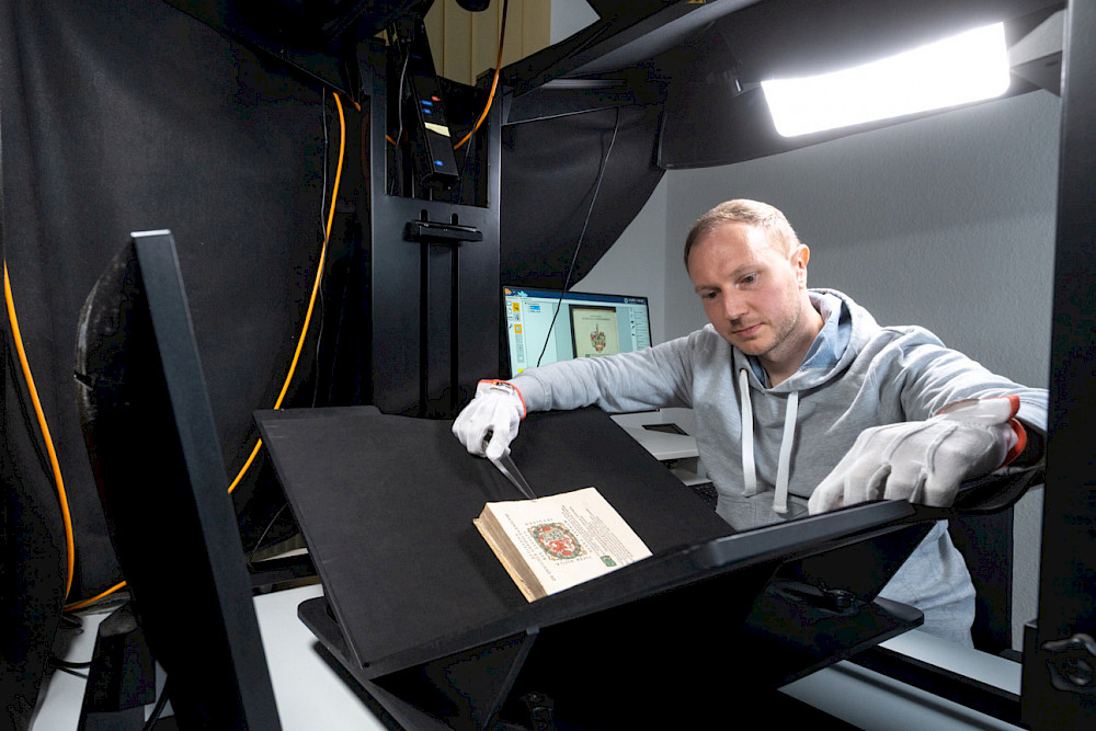 Christian Eisner, Mitarbeiter in der ULB, digitalisiert ein Buch aus dem Jahr 1596 aus der von Alvenslebenschen Bibliothek.